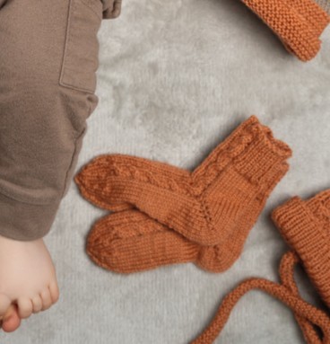 Artikelbild des Artikels “Söckchen mit Zopfmuster aus Pro Lana Baby Merino Soft “
